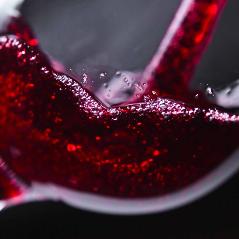 Red wine pouring in glass