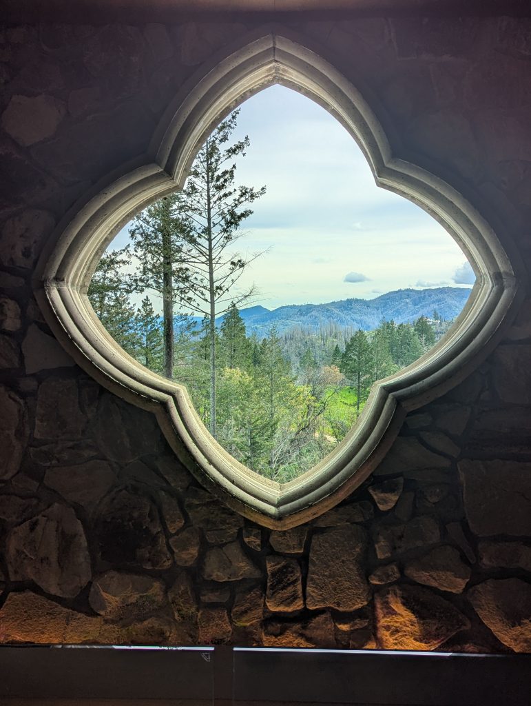 Quatrefoil window framing mountain and forest view at Lokoya winery