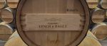 Close-up of a new oak barrel head stamped with the Château Lynch-Bages name and cooperage marking in the barrel room