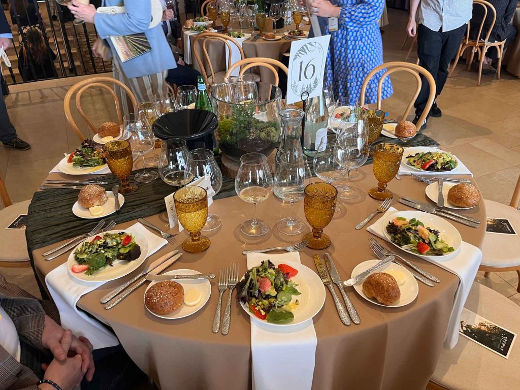 Elegant auction lunch place setting at Domaine Serene with amber glassware, salad course, and Willamette Valley wine