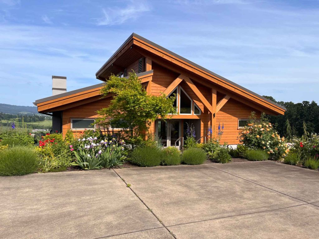 Penner-Ash Wine Cellars timber frame tasting room exterior with wildflower garden in Willamette Valley Oregon